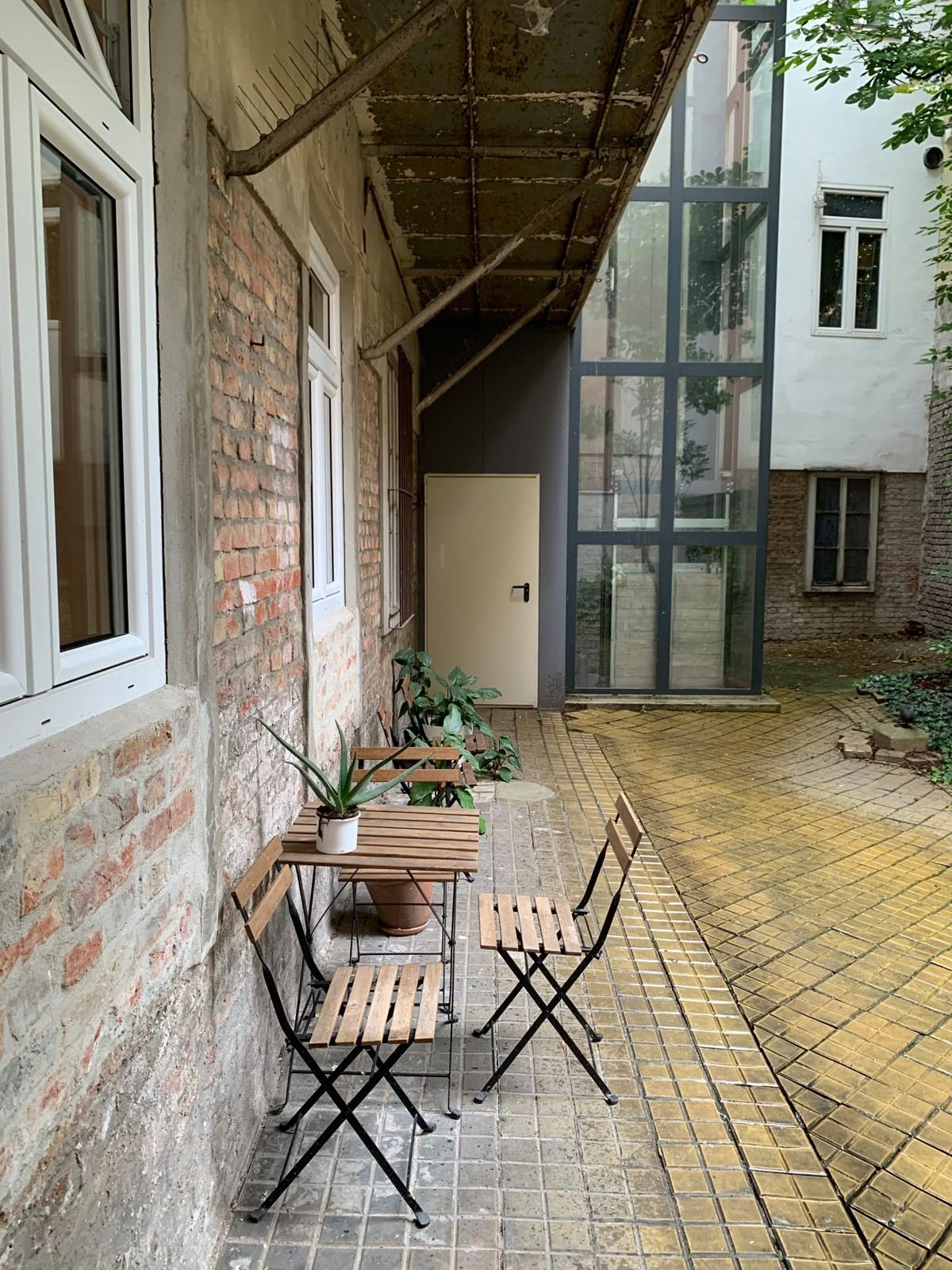 Tisch und Stühle im begrünten Innenhof