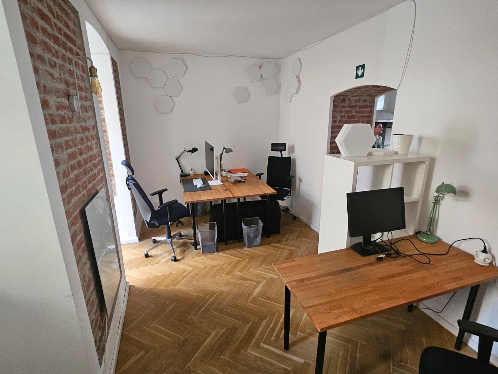 Arbeitsraum mit mehreren Schreibtischen und Akustikpaneelen in Wabenform