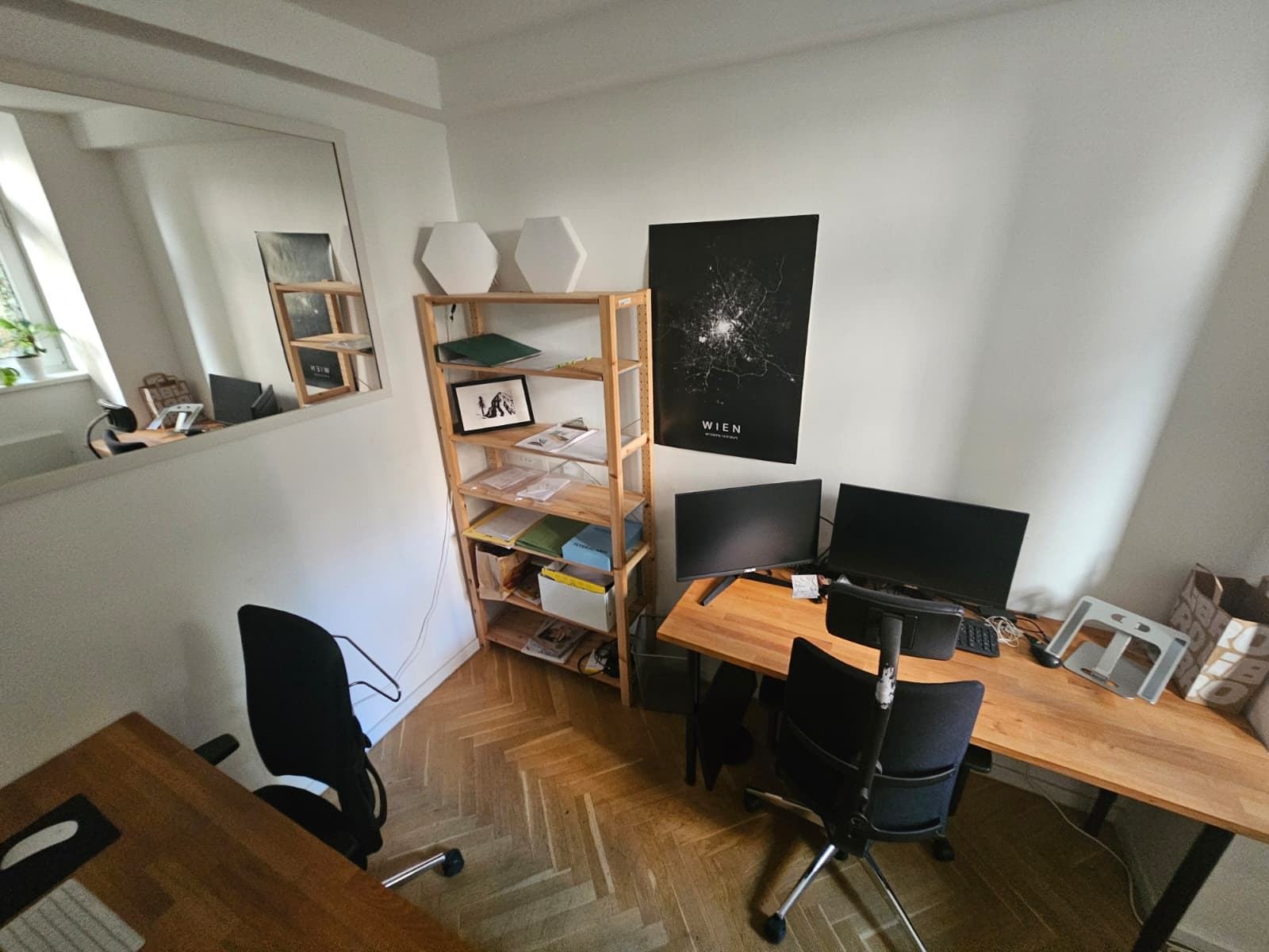 Zwei Arbeitsplätze mit Regal und Wien-Poster